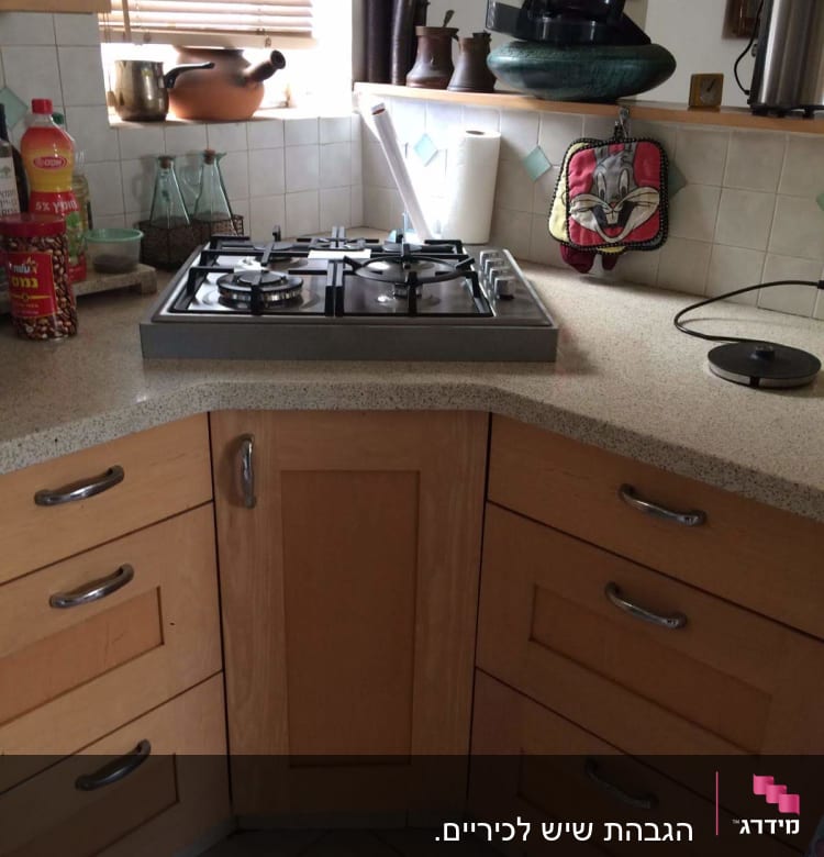 מטבח עם משטח שיש, כיריים וכלים שונים